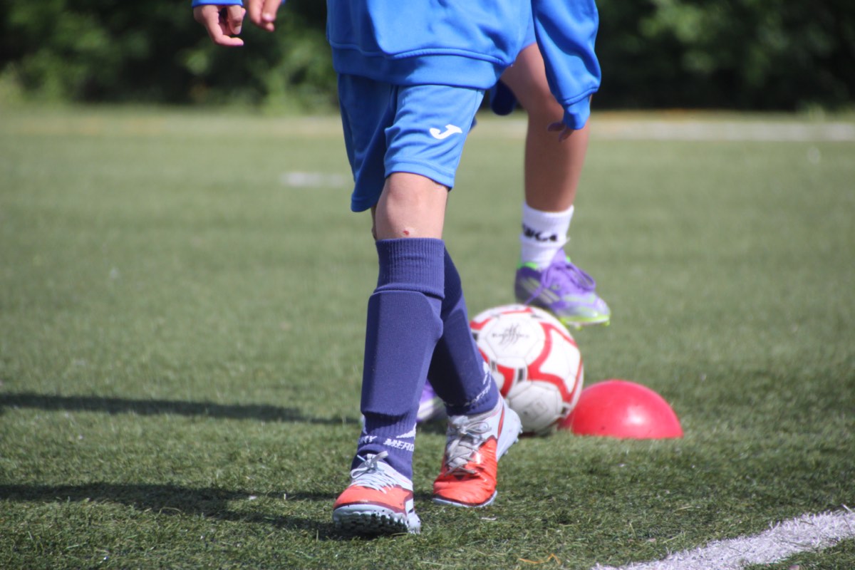 Jugador conduciendo el balón entre conos en un entrenamiento de ÍscarCup Tecnificación