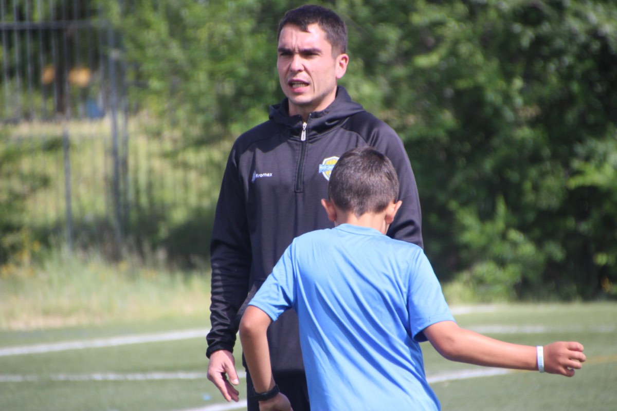 Técnico explicando una tarea a un jugador durante la sesión de domingo